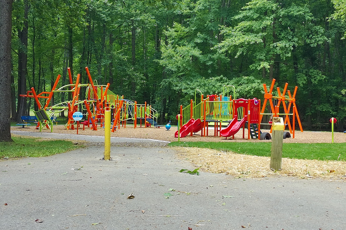 Accessible play area with climbing structures, slides, and gathering spaces for families.