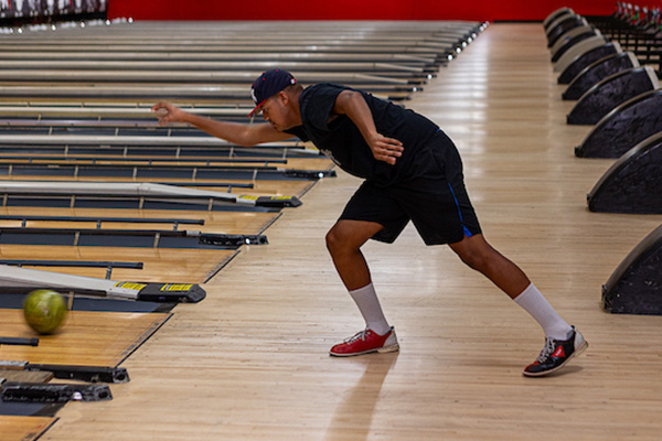A man bowling in a bowling alley.