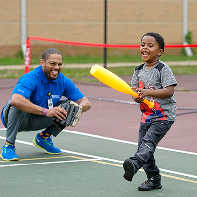 A man and a boy practicing T-Ball