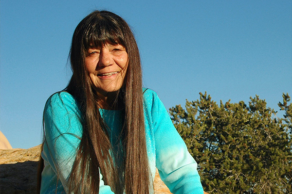 Headshot of a woman with long, dark hair wearing a turquoise sweater.